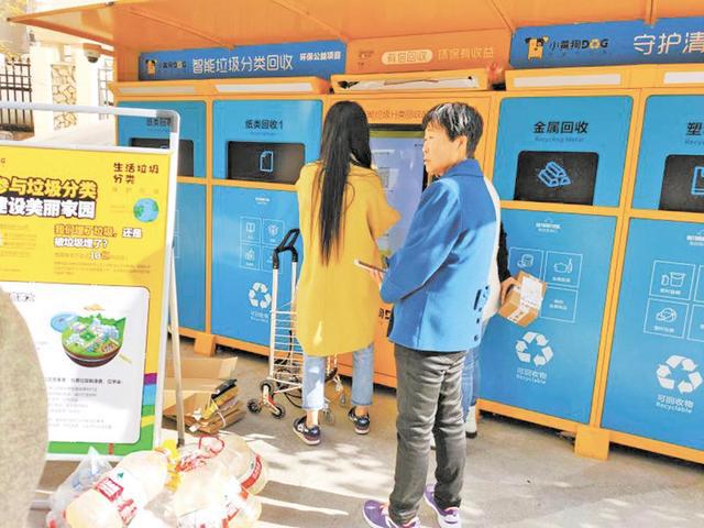 居住在海宏壹号小区D区的居民们正在使用“小黄狗”智能垃圾分类回收机进行垃圾分类及投递。
