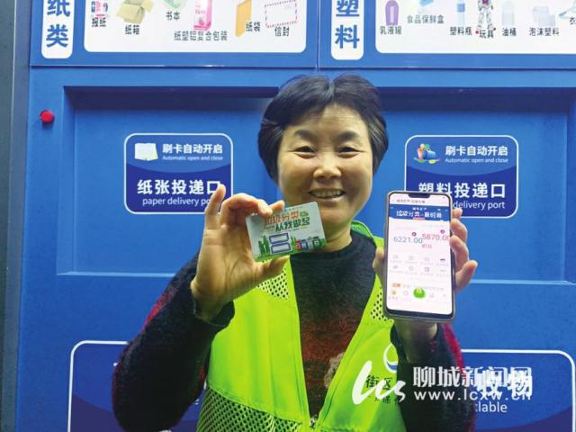 11月11日，东昌丽都小区北区的环保屋管理员展示投放垃圾的智能卡和垃圾分类积分。