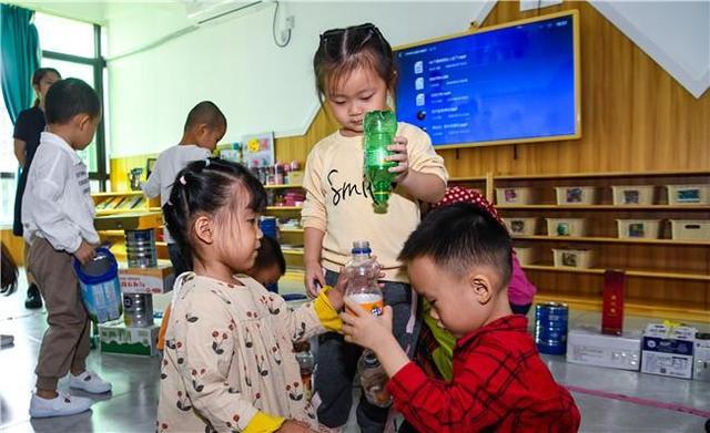 11月2日，海口琼山区蒙爱特幼儿园小朋友在用分类收集的纸箱和饮料瓶做游戏。